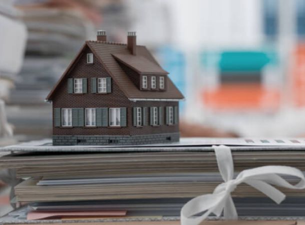 casa in miniatura e documenti